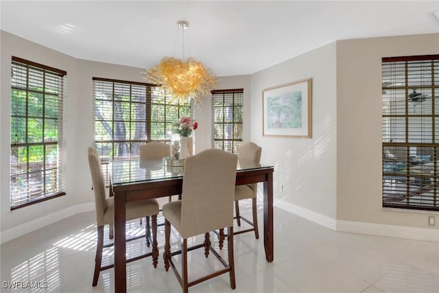 tiled dining space with a chandelier