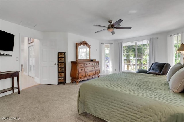 carpeted bedroom with ceiling fan and multiple windows