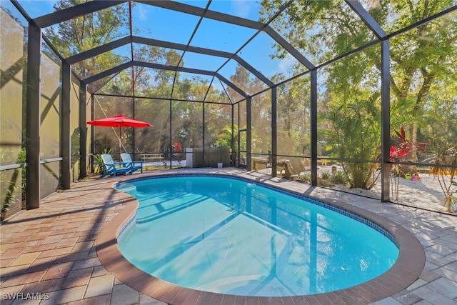 view of pool with a patio and glass enclosure