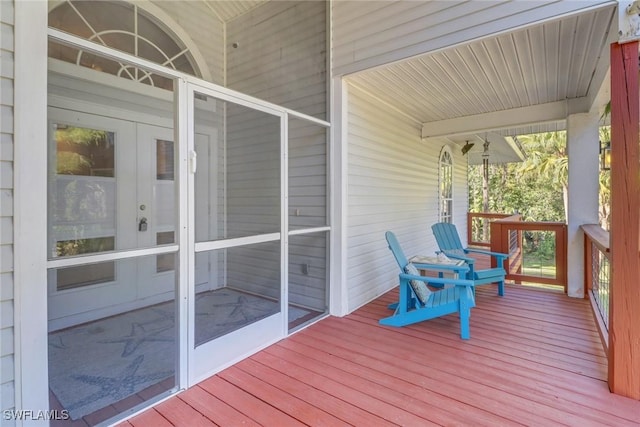 wooden deck with a sunroom