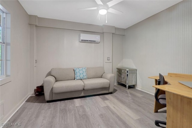 living room featuring ceiling fan, light wood-type flooring, and a wall unit AC