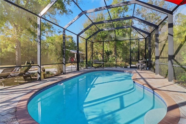 view of swimming pool with a patio and glass enclosure