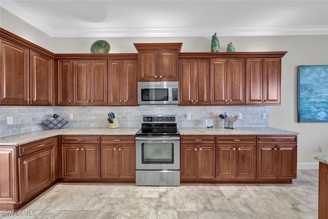 kitchen featuring light stone counters, ornamental molding, appliances with stainless steel finishes, and tasteful backsplash