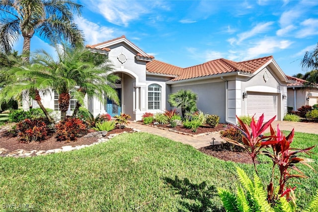 mediterranean / spanish home featuring a garage and a front lawn