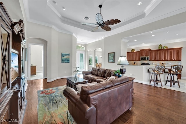 living room featuring a raised ceiling and crown molding