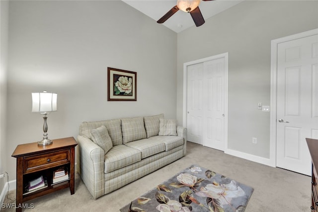 carpeted living room with ceiling fan and lofted ceiling