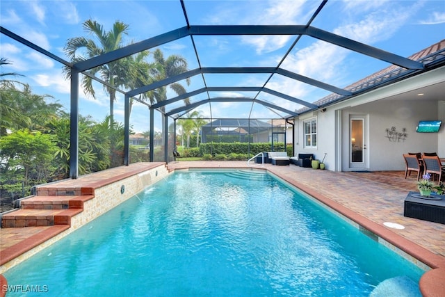 view of swimming pool with pool water feature, a patio, and glass enclosure