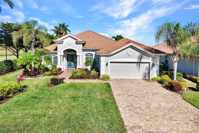 mediterranean / spanish-style house featuring a garage and a front lawn