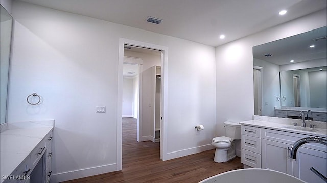 bathroom with vanity, hardwood / wood-style flooring, and toilet