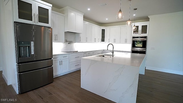 kitchen featuring decorative light fixtures, white cabinetry, stainless steel appliances, and a kitchen island with sink