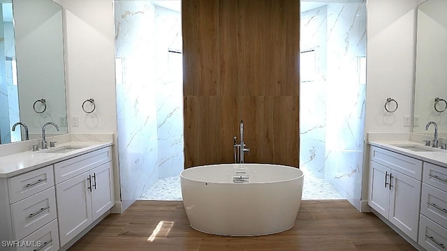 bathroom featuring vanity, a healthy amount of sunlight, wood-type flooring, and plus walk in shower