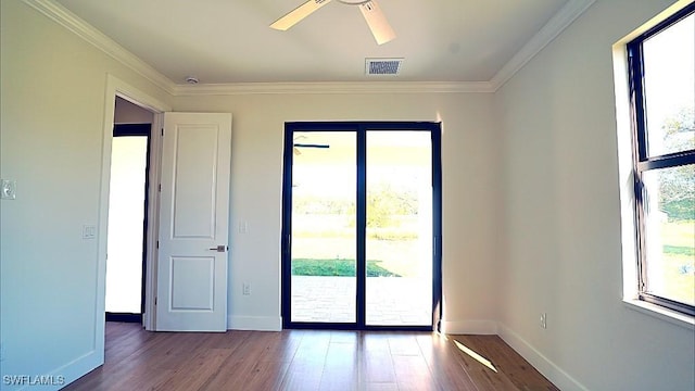 empty room with ceiling fan, hardwood / wood-style floors, and ornamental molding