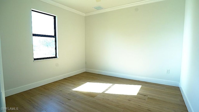 empty room featuring light hardwood / wood-style flooring and ornamental molding