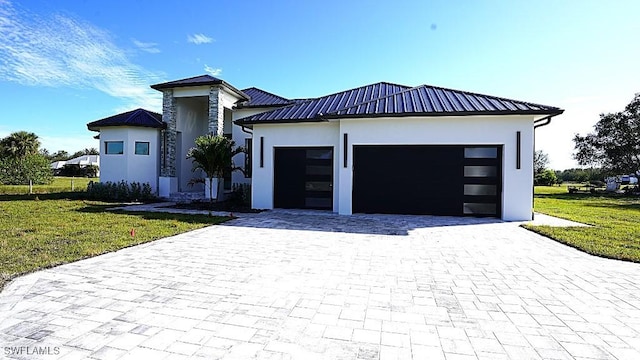 view of front of property featuring a garage and a front lawn