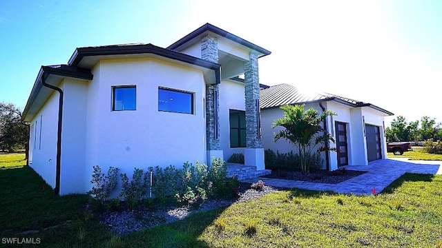 view of home's exterior featuring a garage and a yard