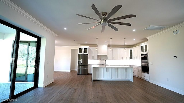 kitchen featuring appliances with stainless steel finishes, ceiling fan, pendant lighting, a center island, and white cabinetry