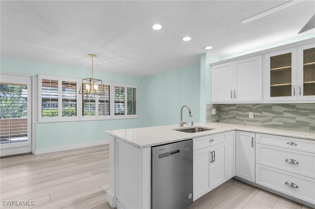 kitchen featuring decorative backsplash, a wealth of natural light, dishwasher, and a sink