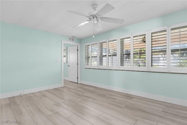 spare room with visible vents, baseboards, ceiling fan, and wood finished floors