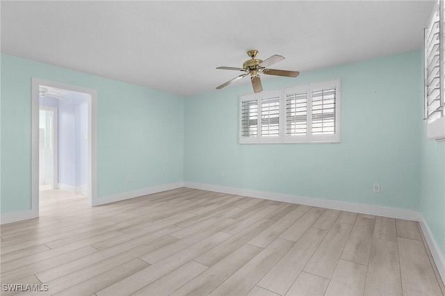 empty room featuring light wood-type flooring, a ceiling fan, and baseboards