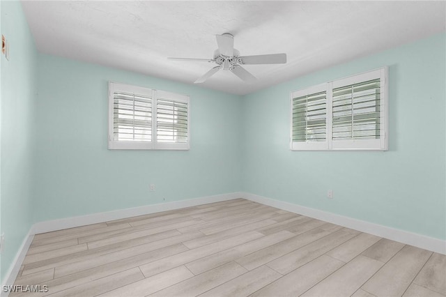 unfurnished room featuring ceiling fan, baseboards, and wood finished floors