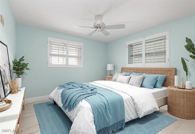 bedroom featuring light wood-style floors, baseboards, and a ceiling fan