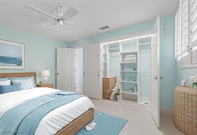 bedroom featuring light wood finished floors, a closet, visible vents, ceiling fan, and baseboards