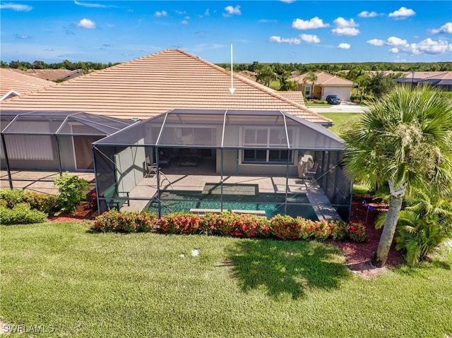 rear view of property with glass enclosure, a yard, and a patio