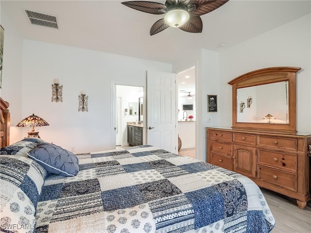 bedroom with ensuite bath, ceiling fan, and light hardwood / wood-style floors