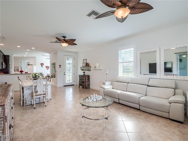 living room with ceiling fan, light tile patterned flooring, and crown molding