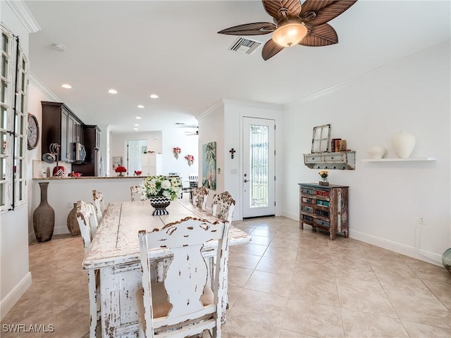 dining area featuring ceiling fan, light tile patterned floors, and crown molding