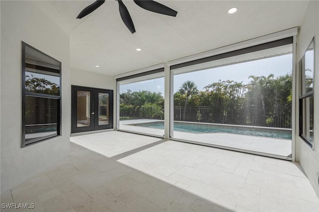 unfurnished sunroom featuring ceiling fan