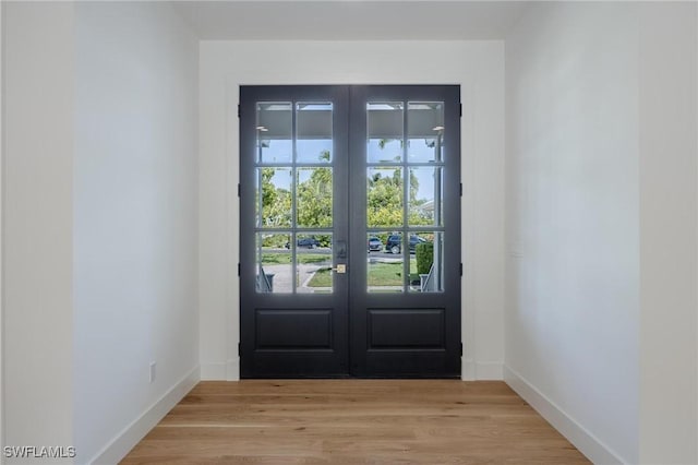 entryway with light hardwood / wood-style floors and french doors