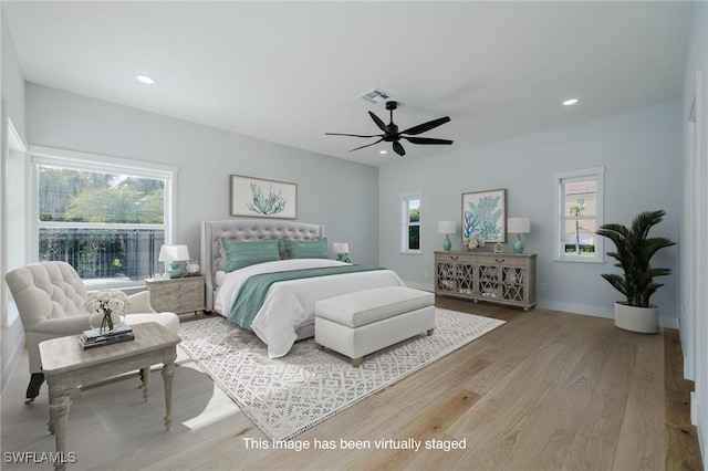 bedroom featuring ceiling fan, light wood-type flooring, and multiple windows