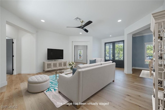 living room featuring french doors, light wood-type flooring, and ceiling fan