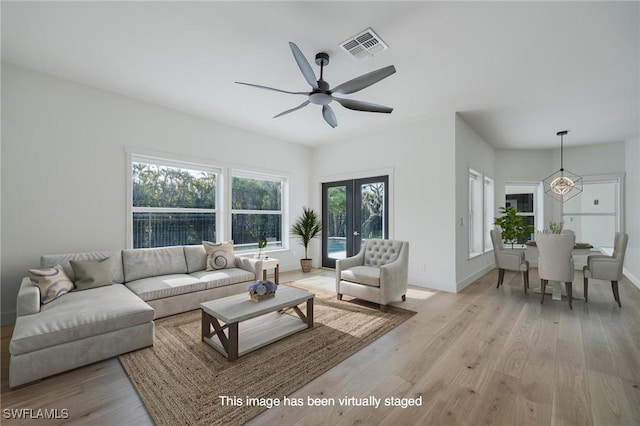 living room with french doors, light wood-type flooring, and ceiling fan