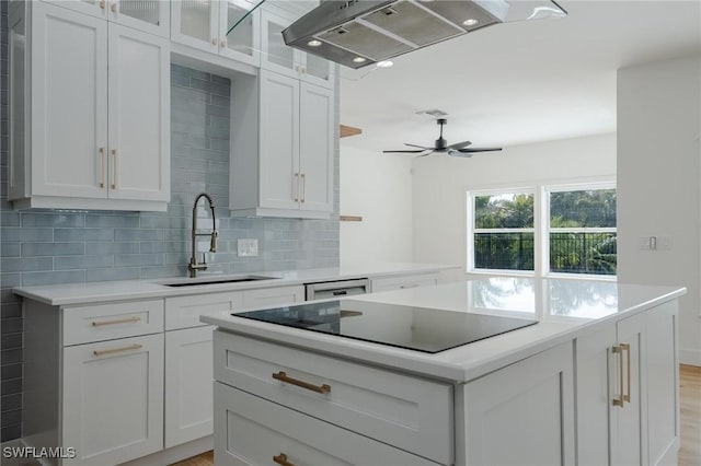 kitchen with ceiling fan, sink, island exhaust hood, black electric stovetop, and white cabinets