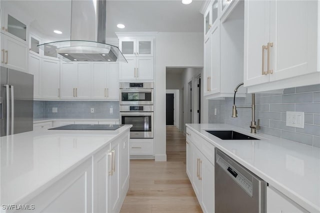 kitchen with white cabinets, sink, tasteful backsplash, island exhaust hood, and stainless steel appliances