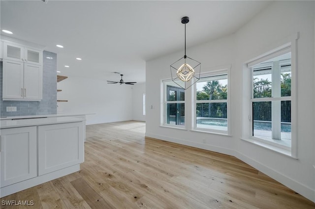 unfurnished dining area with ceiling fan and light hardwood / wood-style floors