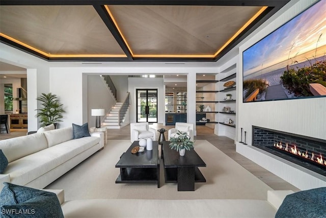 living room featuring a tray ceiling and hardwood / wood-style flooring