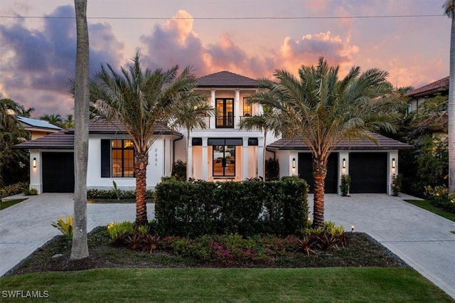 view of front facade with a yard, a balcony, and a garage