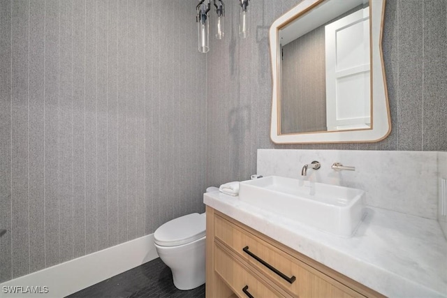 bathroom with vanity, tasteful backsplash, and toilet