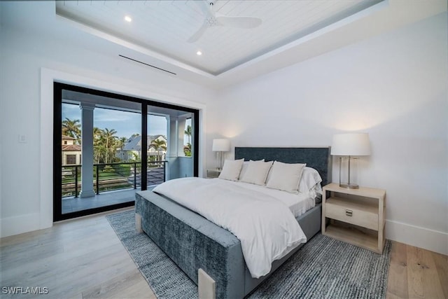 bedroom featuring ceiling fan, wooden ceiling, a raised ceiling, wood-type flooring, and access to outside