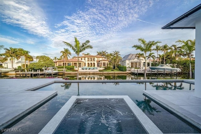 view of pool with a jacuzzi and a water view