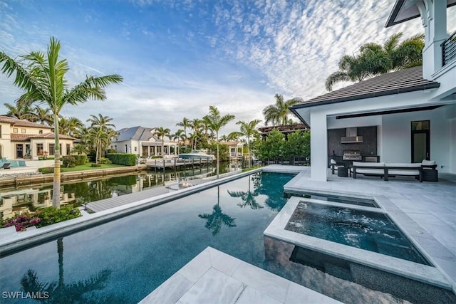 view of pool featuring a fireplace, a water view, an in ground hot tub, and a patio