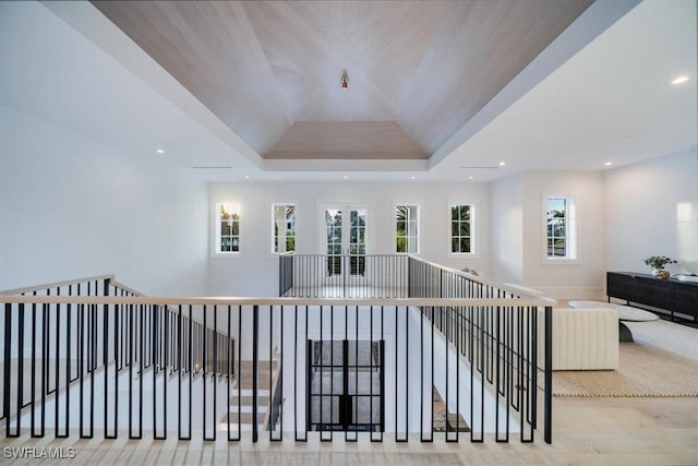 hallway featuring a raised ceiling, french doors, and wooden ceiling