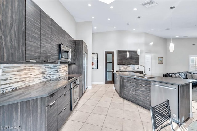 kitchen featuring tasteful backsplash, sink, decorative light fixtures, and appliances with stainless steel finishes