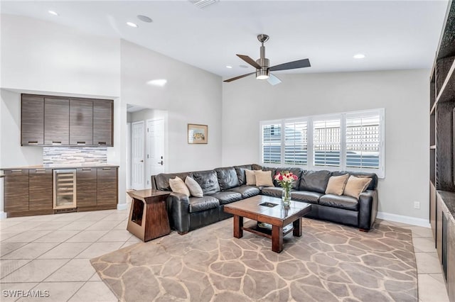 tiled living room featuring ceiling fan, high vaulted ceiling, and beverage cooler