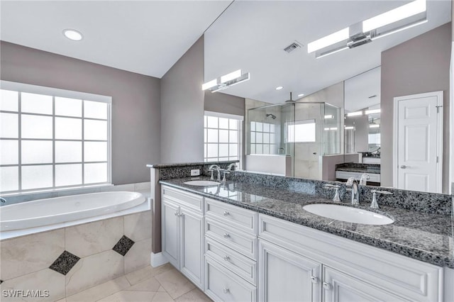 bathroom with tile patterned floors, vanity, and shower with separate bathtub