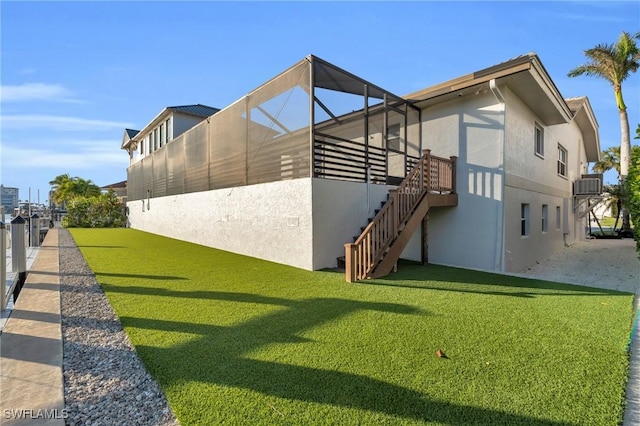 exterior space with a lawn, central air condition unit, and a lanai