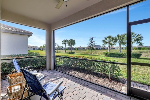 unfurnished sunroom with ceiling fan